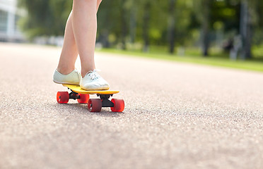 Image showing close up of female feet riding short skateboard