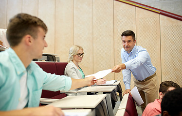 Image showing teacher giving tests to students at lecture