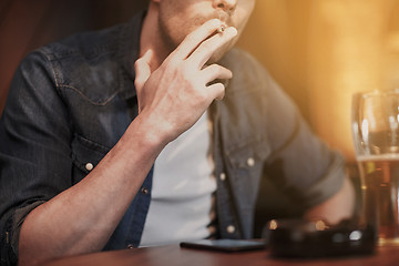 Image showing man drinking beer and smoking cigarette at bar