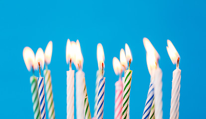 Image showing birthday candles burning over blue background