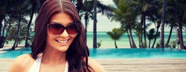 Image showing smiling young woman with sunglasses on beach