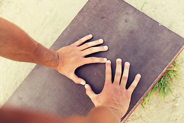 Image showing close up of man hands exercising on bench outdoors