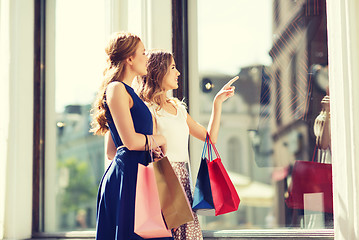 Image showing happy women with shopping bags at shop window