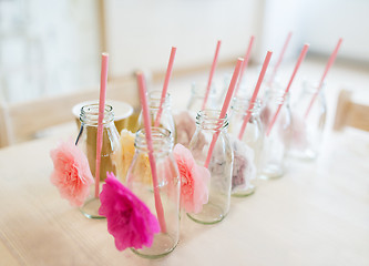 Image showing close up of glass bottles for drinks with straws