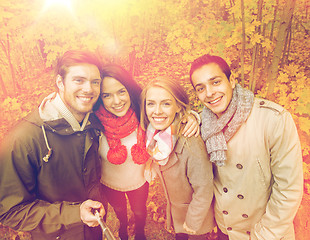 Image showing smiling friends taking selfie in autumn park