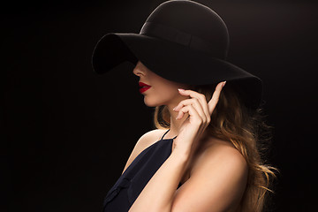 Image showing beautiful woman in black hat over dark background