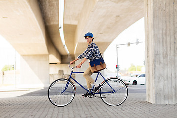 Image showing young hipster man with bag riding fixed gear bike