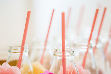 Image showing close up of glass bottles for drinks with straws