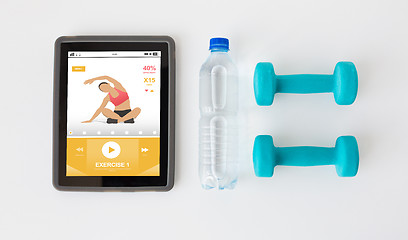 Image showing close up of tablet pc, dumbbells and water bottle