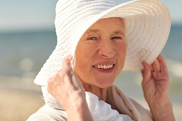 Image showing happy senior woman in sun hat on summer beach