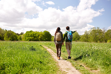 Image showing happy couple with backpacks hiking outdoors