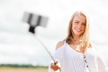 Image showing happy young woman taking selfie by smartphone