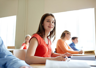 Image showing happy student girl with book writing school test