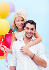 Image showing couple with colorful balloons at seaside