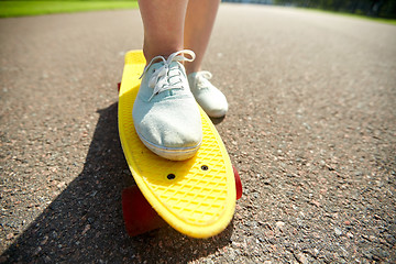 Image showing close up of female feet riding short skateboard