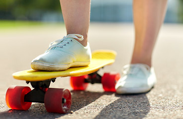 Image showing close up of female feet riding short skateboard