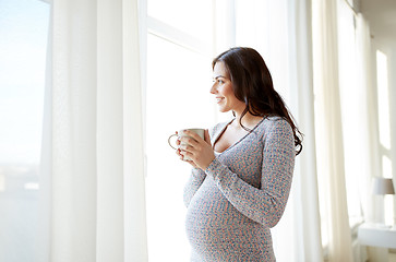 Image showing happy pregnant woman with cup drinking tea at home