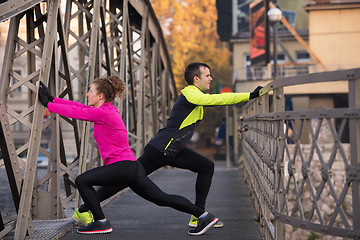 Image showing couple warming up before jogging