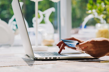 Image showing woman using laptop with credit card in hand