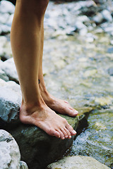 Image showing Barefoot woman standing on stone