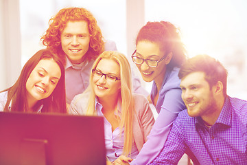 Image showing smiling business team looking at computer monitor