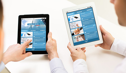 Image showing close up of hands with business news on tablet pc