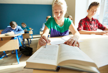 Image showing group of students with books writing school test