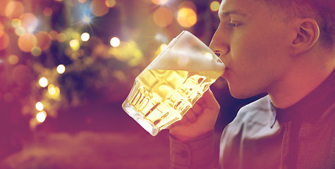 Image showing close up of young man drinking beer from glass mug