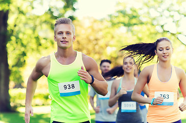 Image showing happ young sportsmen racing wit badge numbers