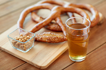 Image showing close up of beer, pretzels and peanuts on table