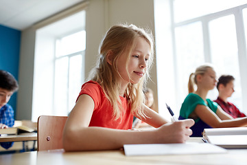 Image showing student girl with book writing school test