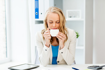 Image showing happy businesswoman drinking coffee at office