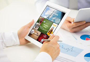 Image showing close up of hands with news page on tablet pc