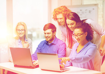 Image showing smiling team with laptop computers in office