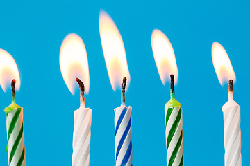Image showing birthday candles burning over blue background
