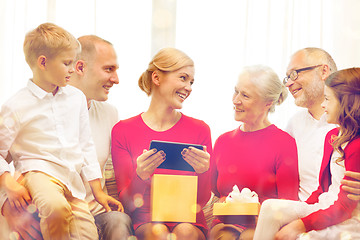 Image showing smiling family with tablet pc and gift box at home