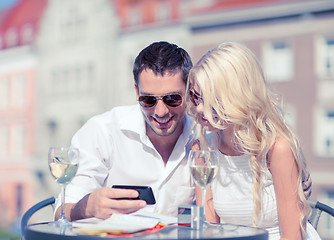 Image showing couple looking at smartphone in cafe