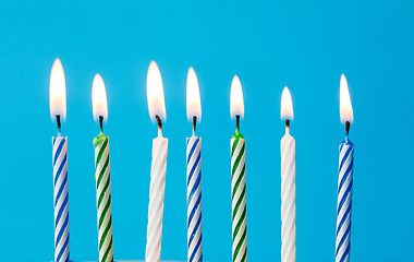 Image showing birthday candles burning over blue background