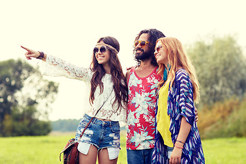 Image showing smiling young hippie friends on green field