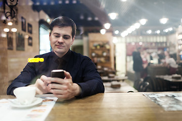 Image showing Gentleman sitting at the table using phone