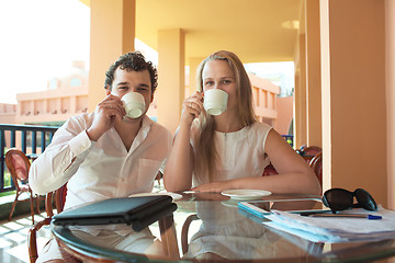 Image showing Young couple drinking coffee on a balcony