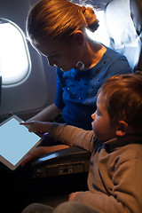 Image showing Mother traveling on a plane with her small son