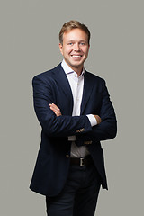 Image showing Cheerful businessman with crossed arms isolated on grey