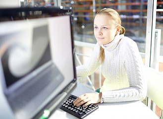 Image showing Young girl is choosing the notebook.