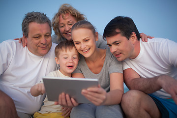 Image showing Happy family spending time with pad outdoor