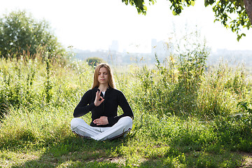 Image showing Young woman practicing yoga in the city park