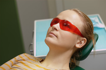 Image showing Woman in red safety glasses in dental office