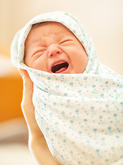 Image showing Crying newborn in mothers hands