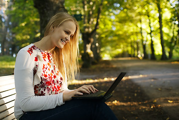 Image showing Young woman using her laptop in the park