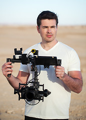 Image showing Videographer with steadicam equipment on the beach